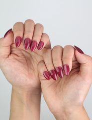 Elegant look created with Wine Illusion Singapore press on nails, handmade with a wine-tone cat eye finish.