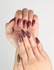 Close-up of hands with Wine Velvet deep red almond Singapore press on nails by Naillover, highlighting the bold almond shape and handmade detail.