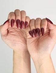 Wine Velvet deep red almond Singapore press on nails styled by Naillover, paired with an elegant outfit for a chic evening look.