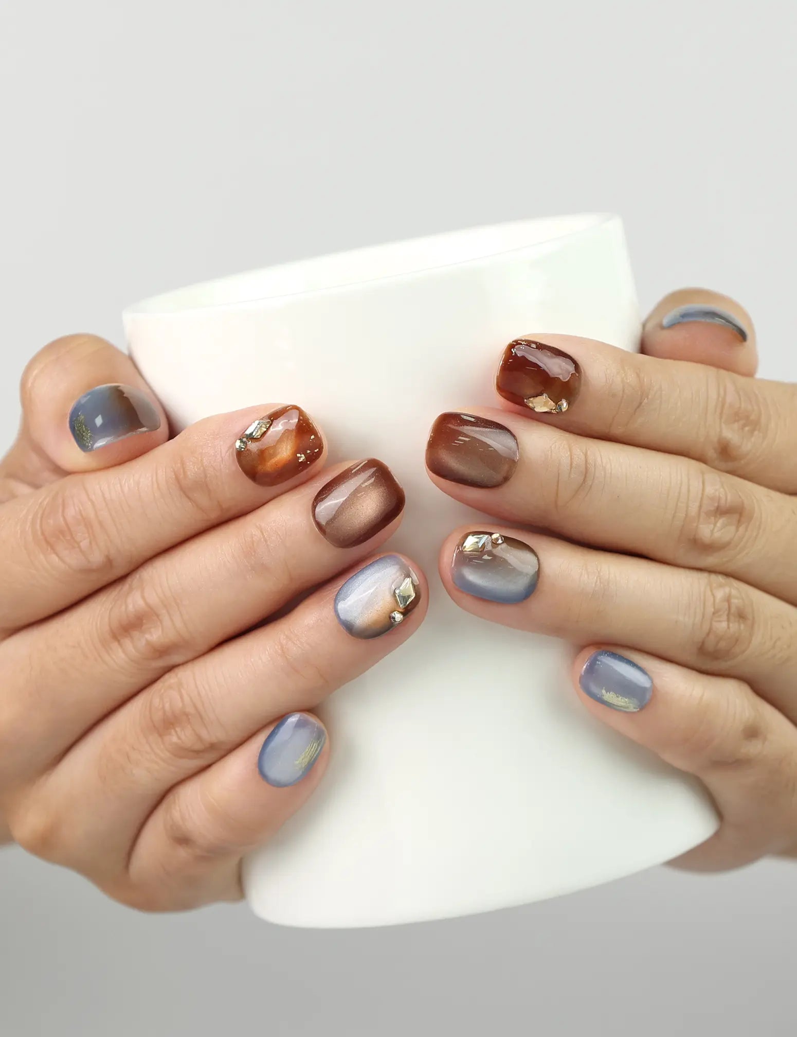 Amber Glow handmade Singapore press on nails styled while holding a cup, glossy amber gradient shine