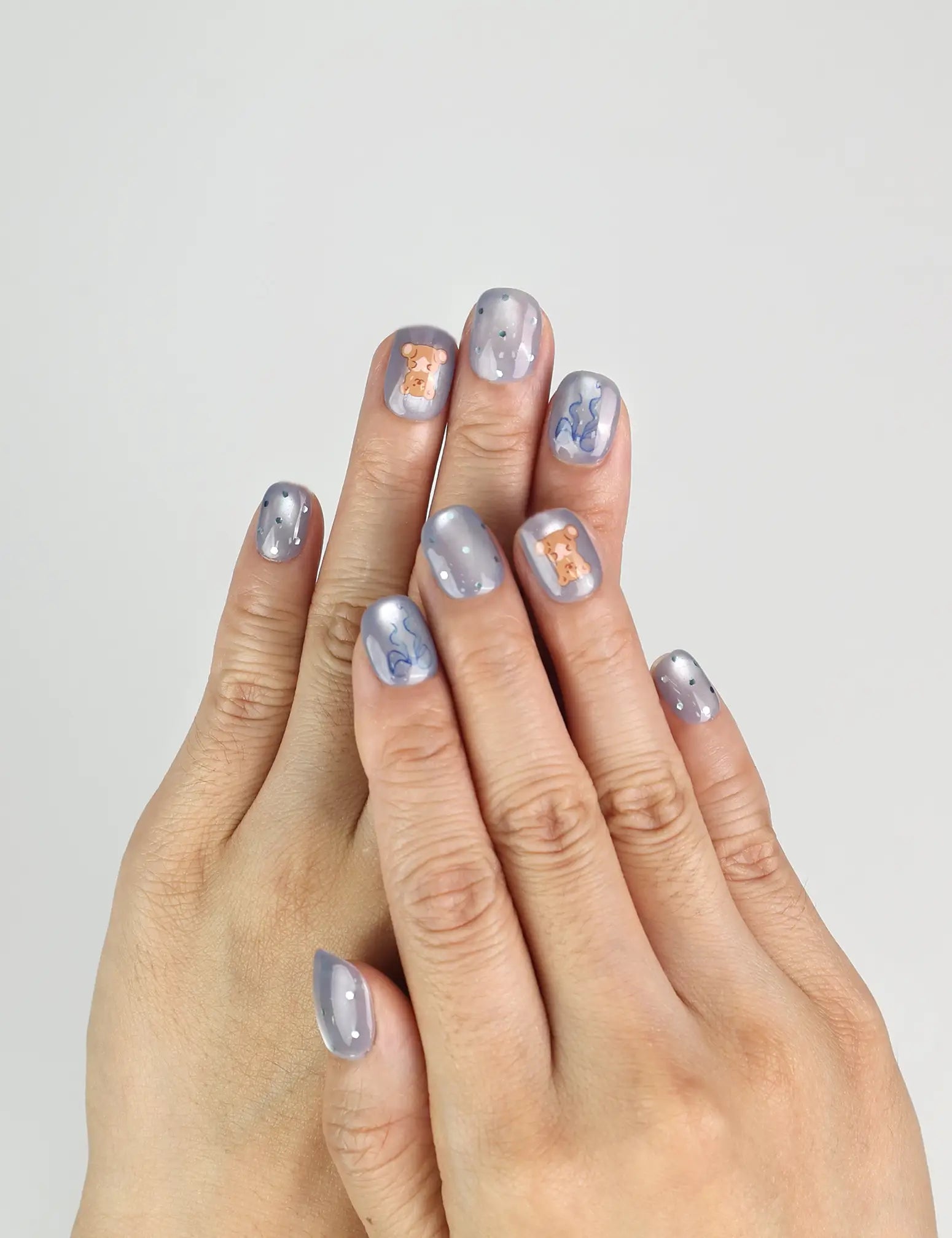 Model wearing Aqua Flash Singapore press on nails with glossy blue, ribbon, and summer design