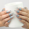 Hand holding a drink while wearing Aqua Wave Singapore press on nails with shimmering aquatic design
