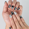 Close-up of Naillover’s handmade Singapore nails featuring black base and shimmering silver rabbit charms