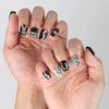Side view of edgy black press-on nails with high-shine gloss and playful 3D bunny figures