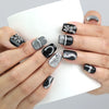 Hand holding a cup, showcasing Naillover’s short coffin black nails with standout silver bunny charms