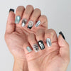 Side view of modern black square nails with statement balloon art and futuristic shimmer