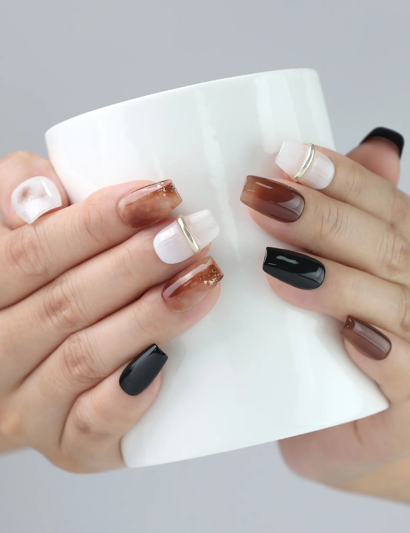 Woman holding cup with Naillover Blend Black Singapore press on nails, reflecting refined simplicity for casual outings.