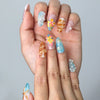 Close-up of Naillover’s handmade summer nails with 3D flower designs, ocean shell details, and soft beach tones