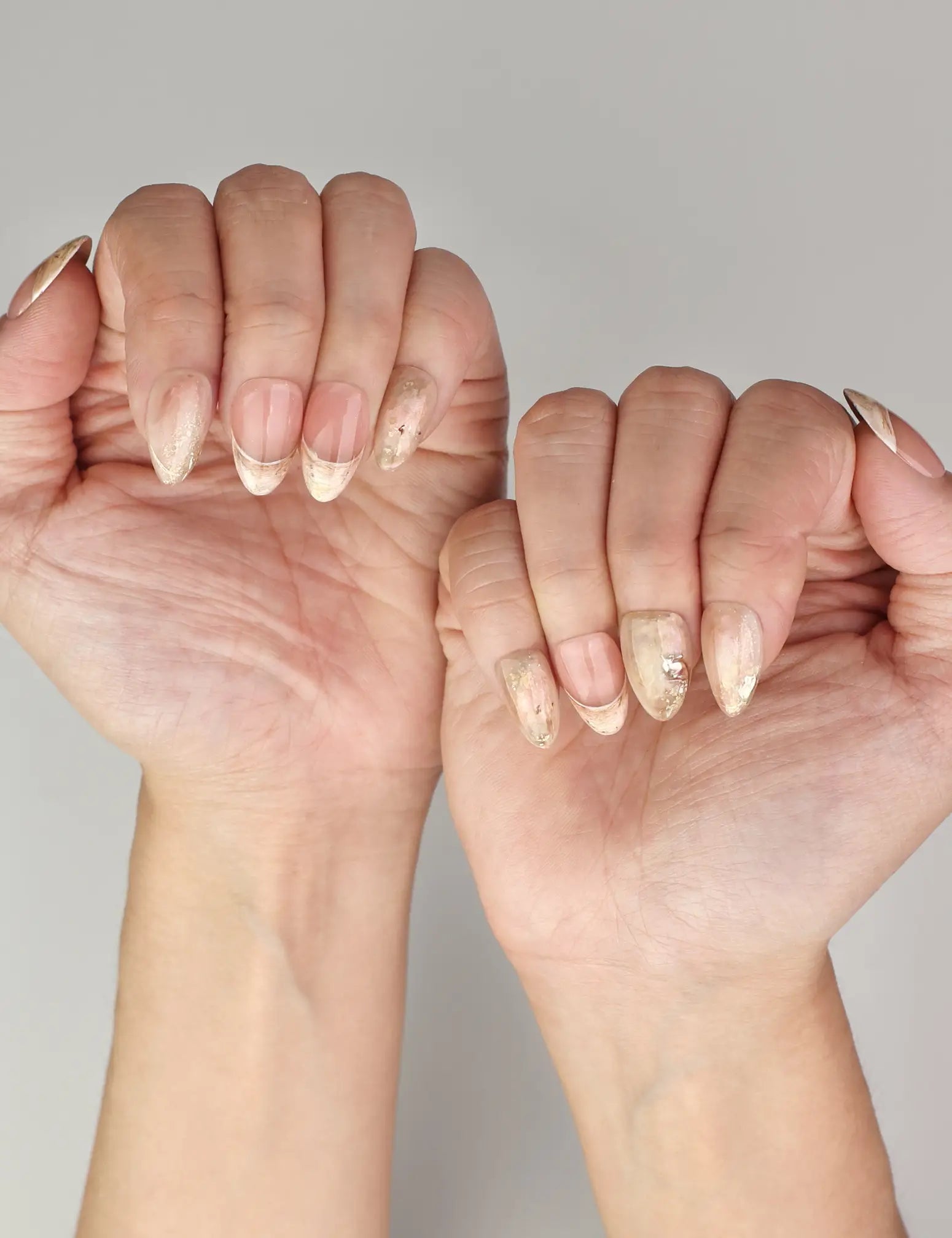 Naillover Blush Amber Grace handmade press on nails styled on hand with peach beige marble and subtle gold accents.