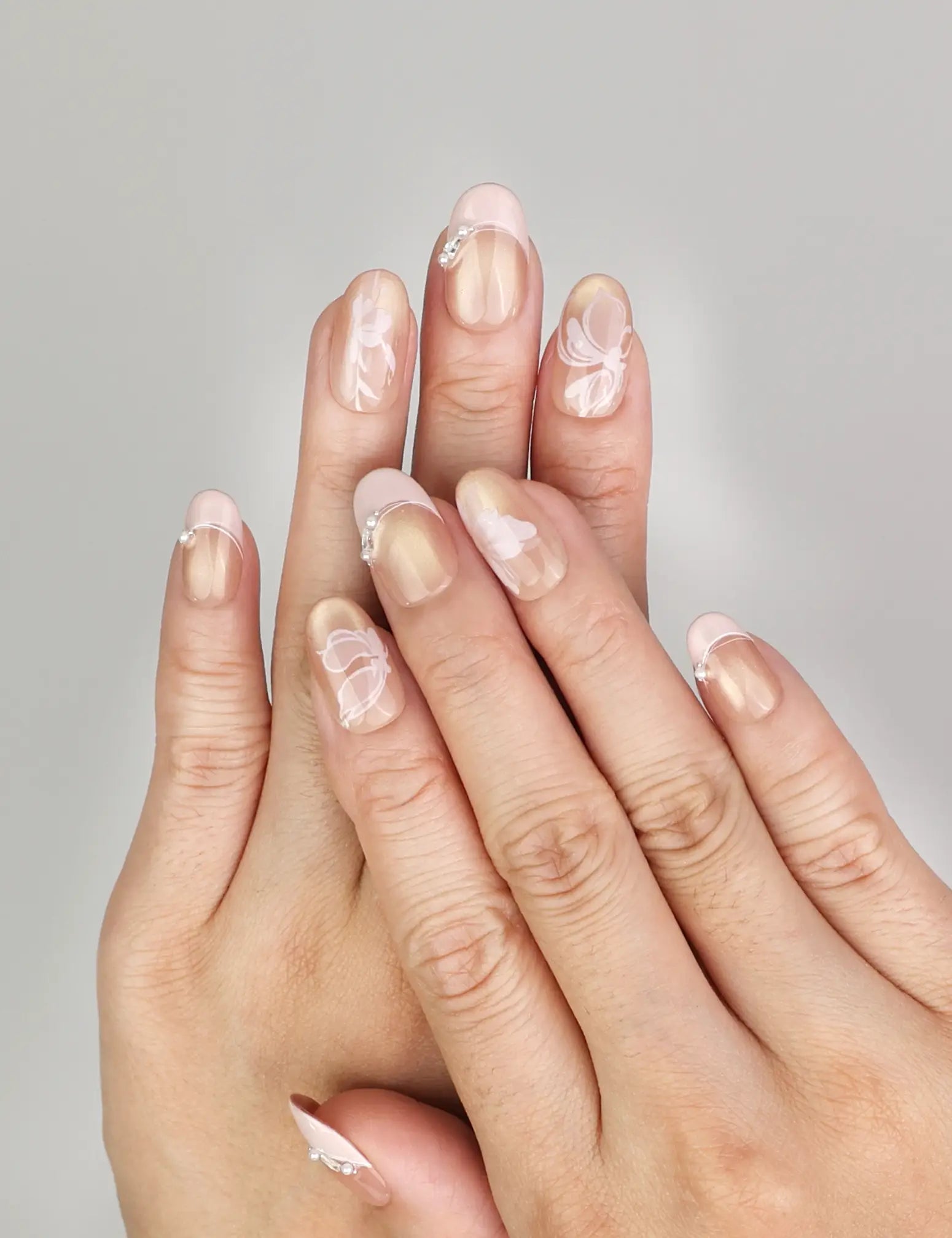 Hand wearing Naillover Blush Latte handmade press on nails with nude ombre finish, metallic stripes, and subtle pearlescent accents.