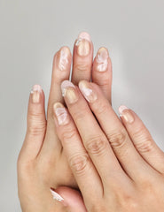 Hand wearing Naillover Blush Latte handmade press on nails with nude ombre finish, metallic stripes, and subtle pearlescent accents.