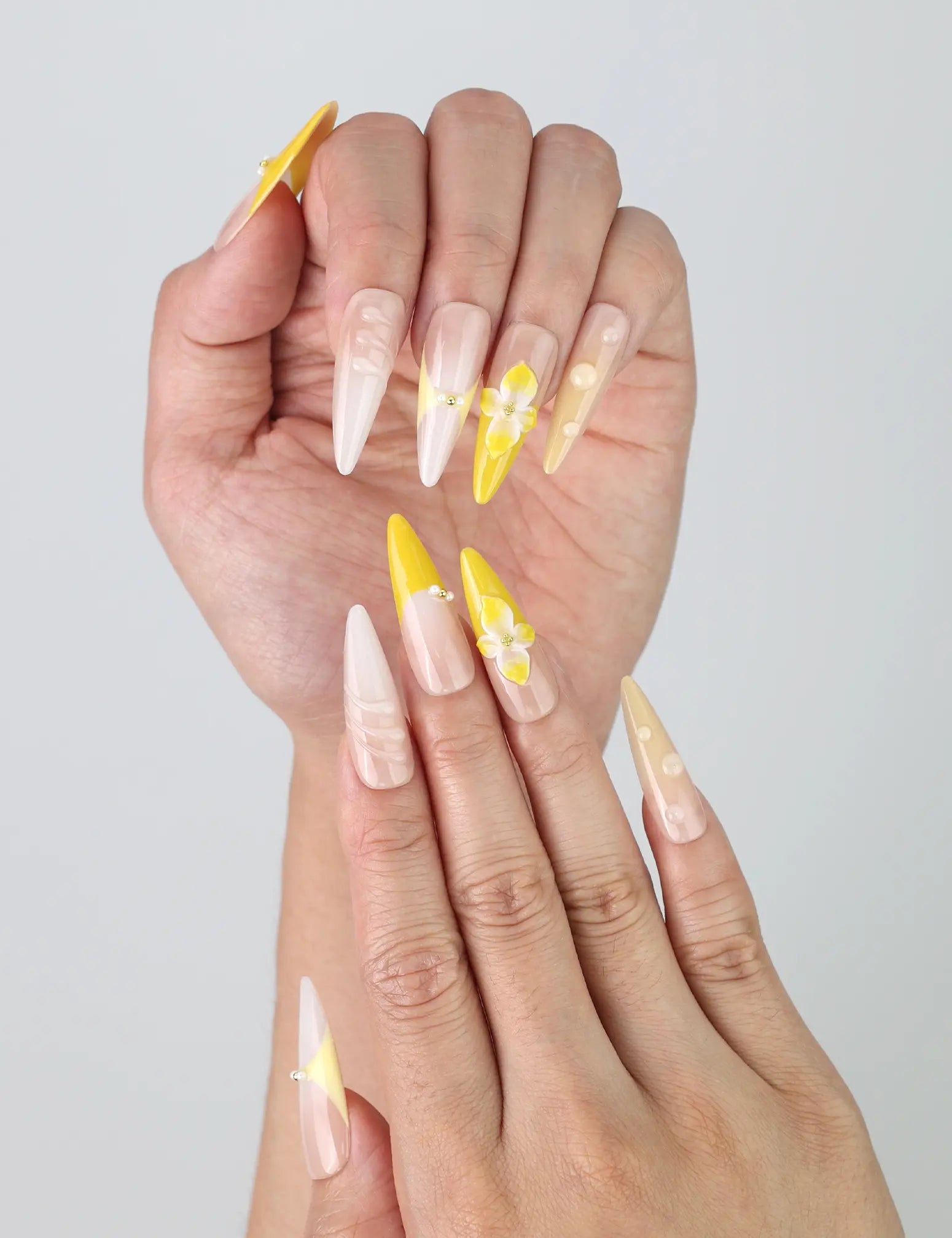Close-up of handmade stiletto nails from Singapore with dramatic 3D metallic swirls in deep yellow and cosmic hues