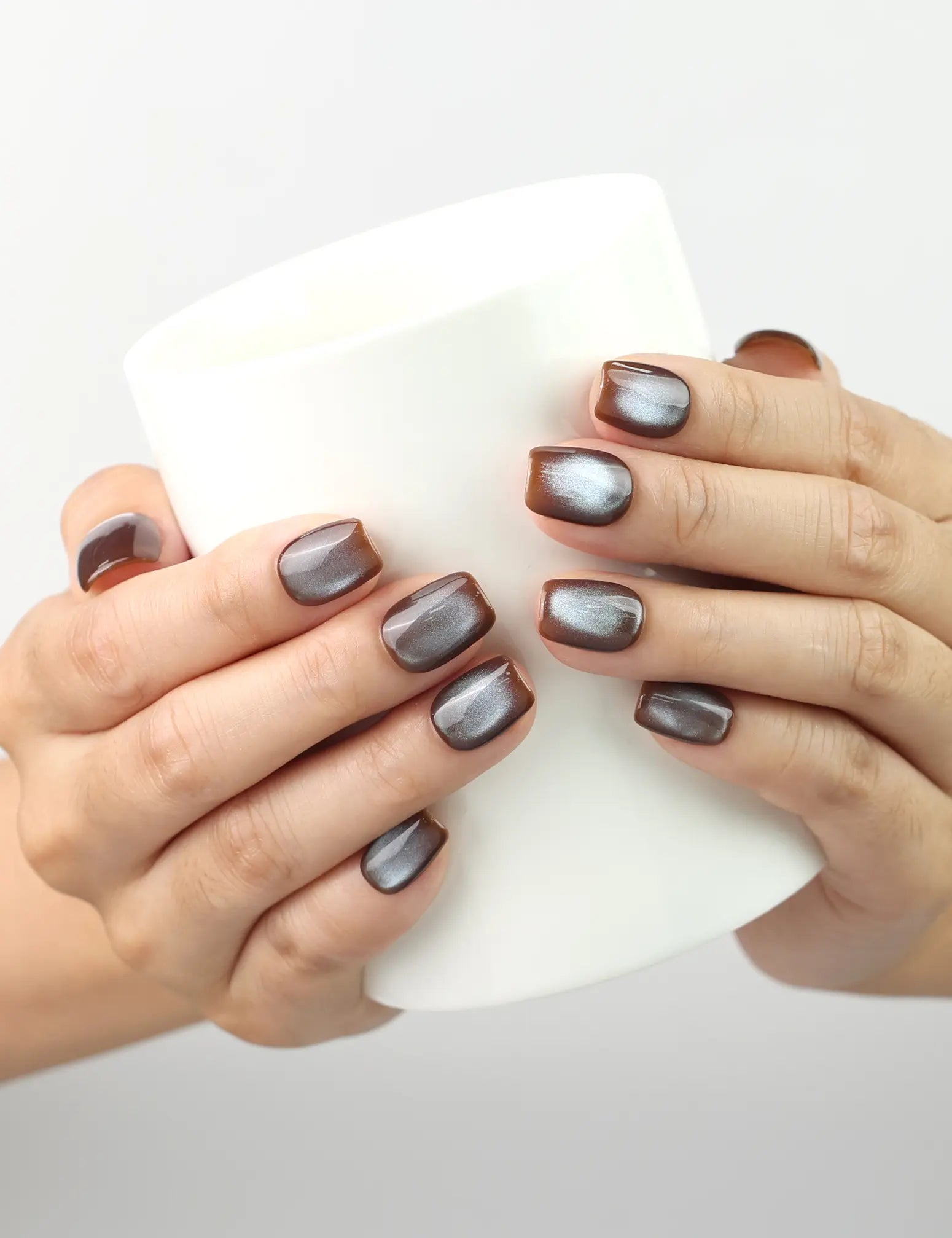 Naillover Bronze Fantasy Singapore press on nails holding a coffee cup with bronze shimmer details