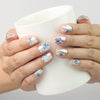 Hand holding a cup while wearing Butterfly Light short press-on nails with blue butterfly details from Naillover Singapore.