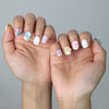 Side view of kawaii press-on nails in soft pink and blue with raised dessert and candy embellishments