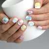 Hand holding a cup, showcasing Naillover’s playful ice cream and gummy bear nails with a sweet, summery look