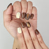 Close-up of fingers showcasing Naillover handmade Caramel Glaze cat eye nails in Singapore.