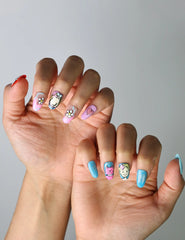 Vibrant and quirky short nails with glossy finish, featuring doodled stars, faces, and cartoon-inspired art