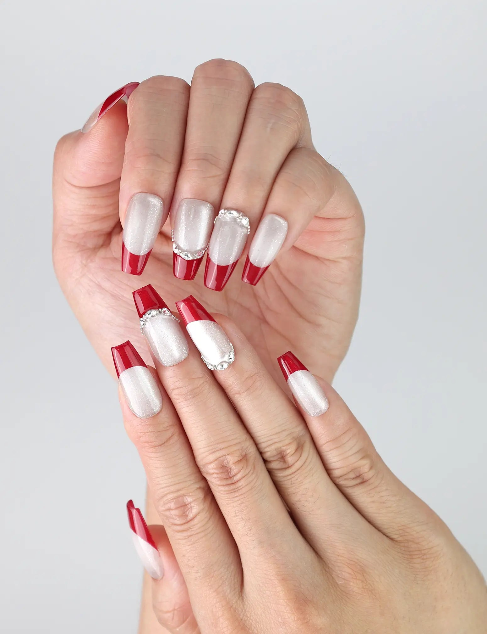 Close-up of Naillover’s handmade red coffin nails with bold silver glitter gradient and glossy finish