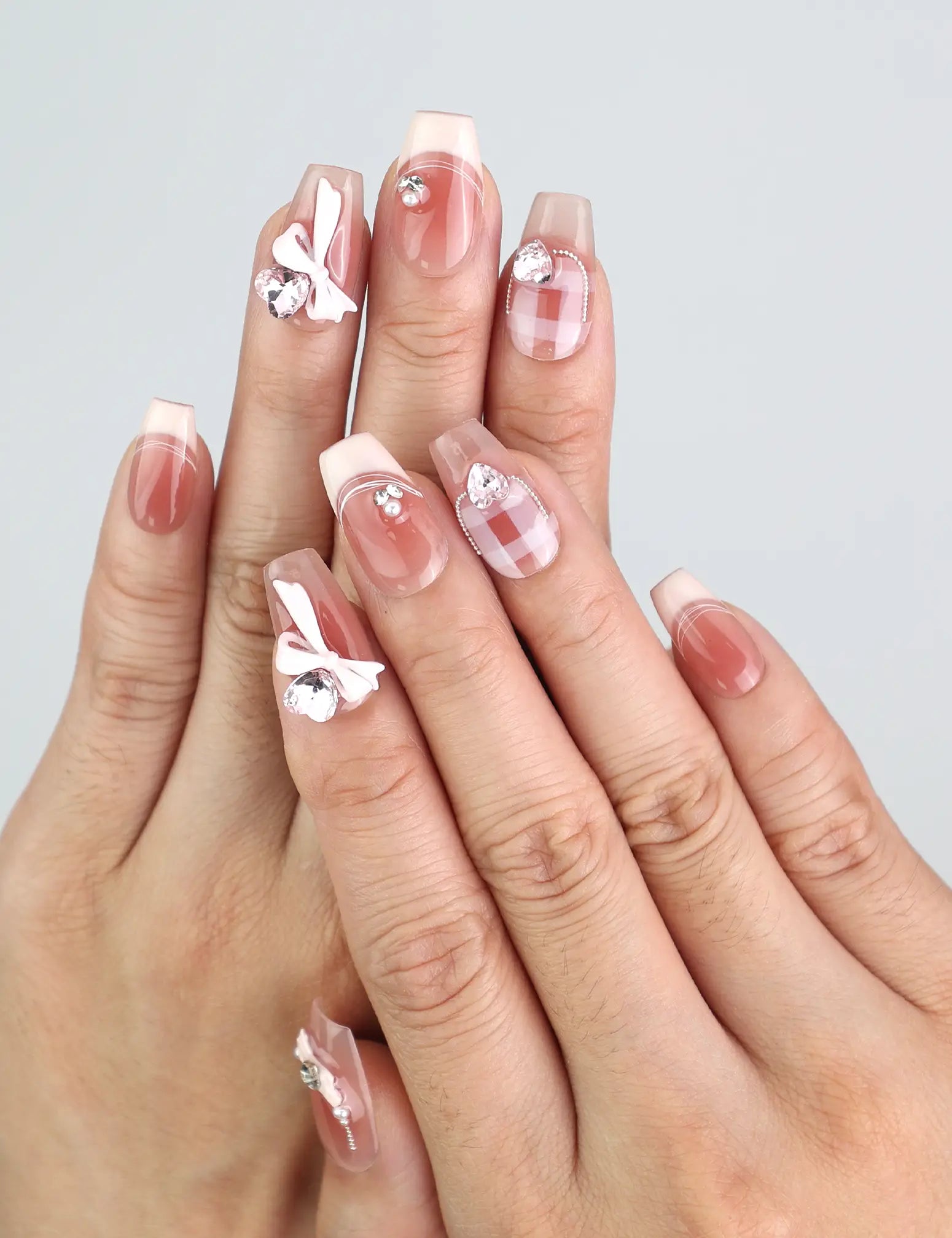 Hand wearing Cherry Bow Crush handmade press on nails with pink gingham and 3D bows from naillover Singapore collection