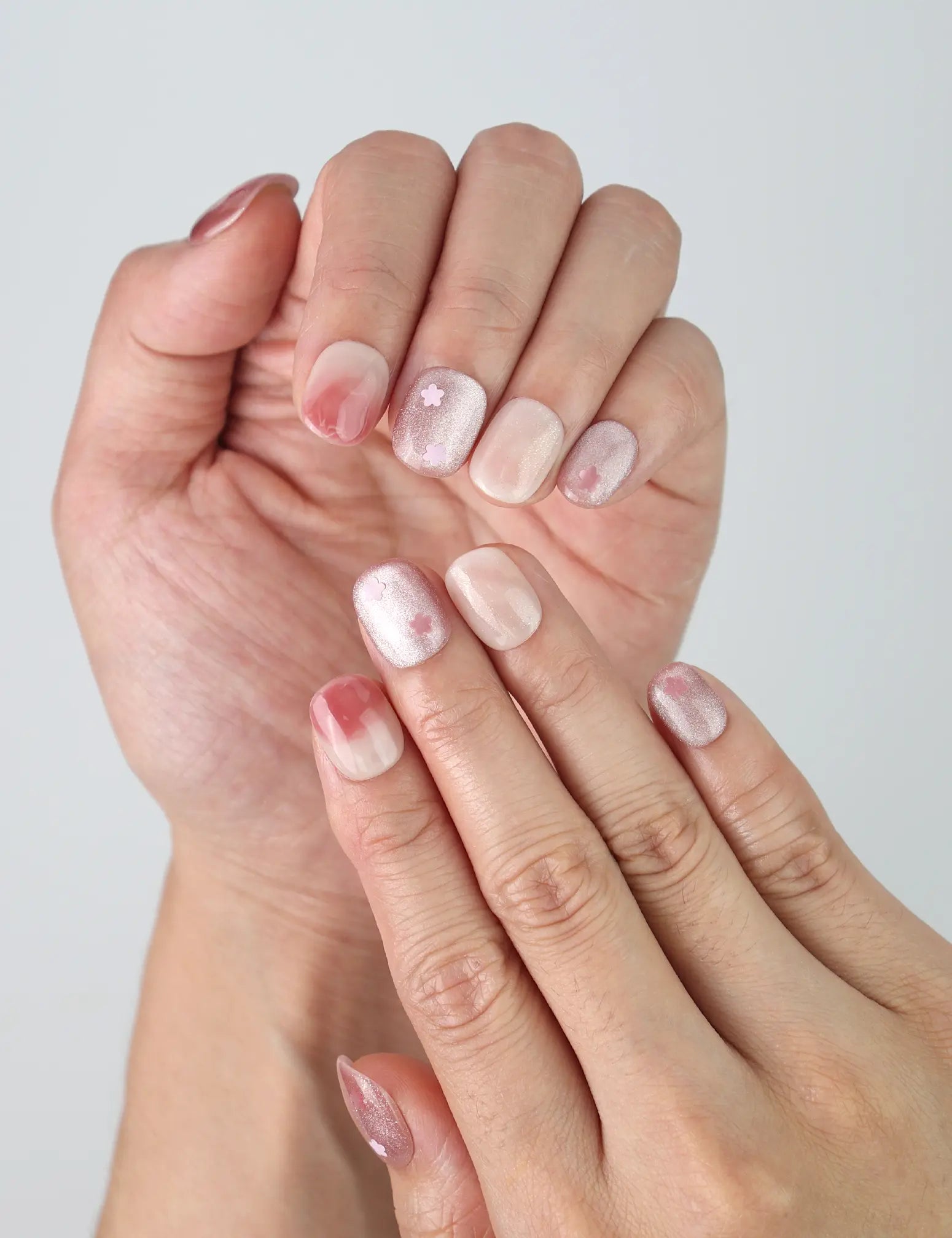 Close-up of Singapore handmade squoval nails with subtle pink floral details on a natural nude base