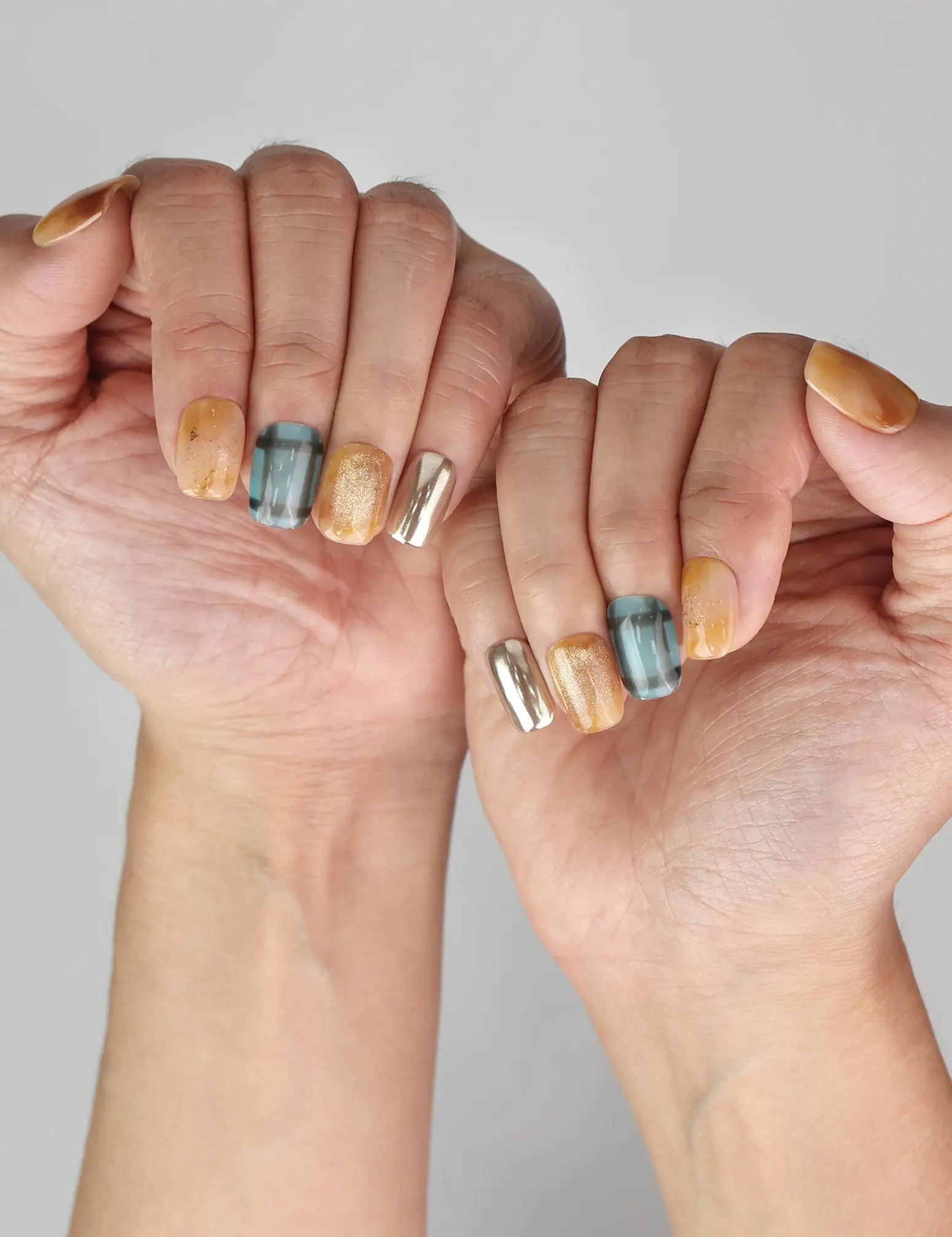 Naillover handmade Cozy Plaid Glaze short coffin nails in plaid and cat-eye shimmer shown on model hand