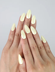 Hand with glossy pastel yellow short almond nails for a sunny and uplifting springtime style