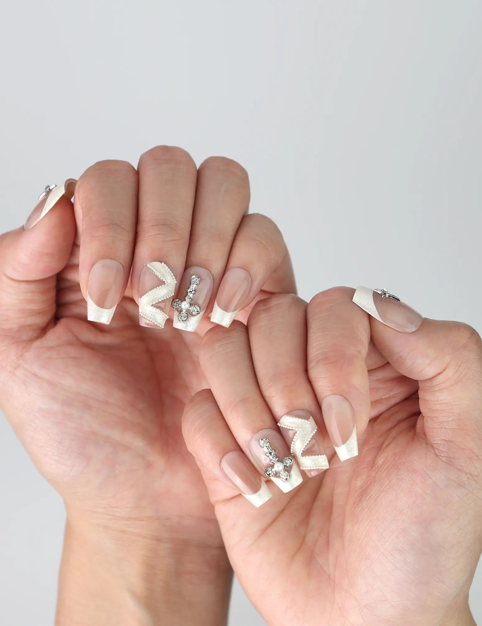 Side angle showing handmade medium coffin nails in nude beige with glam crystal studs and geometric zigzag designs
