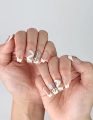 Side angle showing handmade medium coffin nails in nude beige with glam crystal studs and geometric zigzag designs