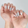 Side view of elegant blue press-on nails with luminous finish and delicate crystal clusters