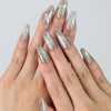 Hand gesture showing medium-length silver press on nails with metallic chrome shine and gem accents by Naillover