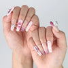 Side view of nude-to-pink gradient press-on nails in coffin shape with elegant marble effect and crystal charm detail