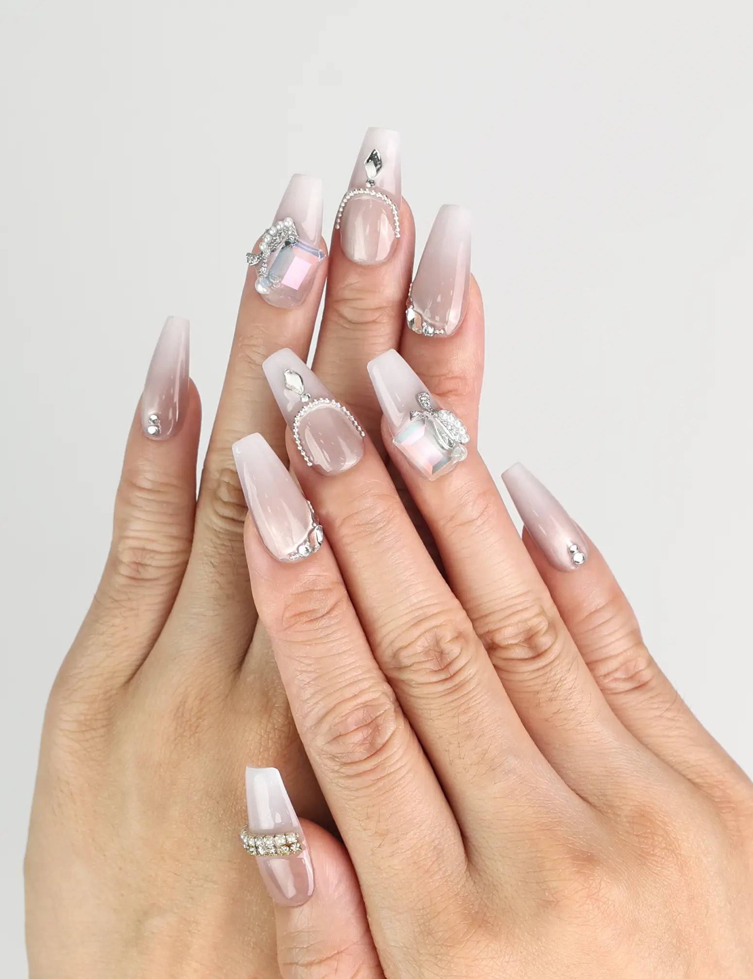 Model wearing Dolce Peach Singapore press on nails in glossy pink coffin shape with silver chain accents by naillover