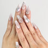 Model wearing Dolce Peach Singapore press on nails in glossy pink coffin shape with silver chain accents by naillover
