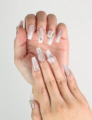 Close-up of Dolce Peach handmade Singapore press on nails in pink with silver chain accents