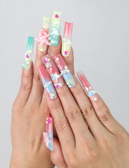 Hand gesture showcasing Singapore handmade long pipe press on nails with 3D floral art, ocean wave designs, and gold starfish accents by Naillover