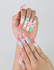 Fingers splayed to display intricate ocean-inspired long pipe nails with 3D flowers and metallic starfish by Naillover