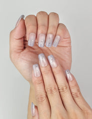 Close-up of Eclipse Stars cat eye nails on hand, showing shimmering gradient and delicate star embellishments