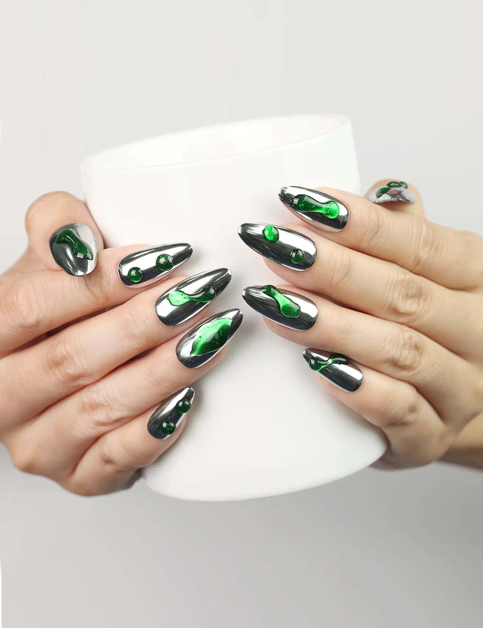 Emerald Wave handmade press-on nails Singapore with silver base and emerald accents, model holding coffee cup by naillover