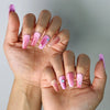 Side view of coffin-shaped press-on nails in romantic pink-red hues with bold gem sparkle