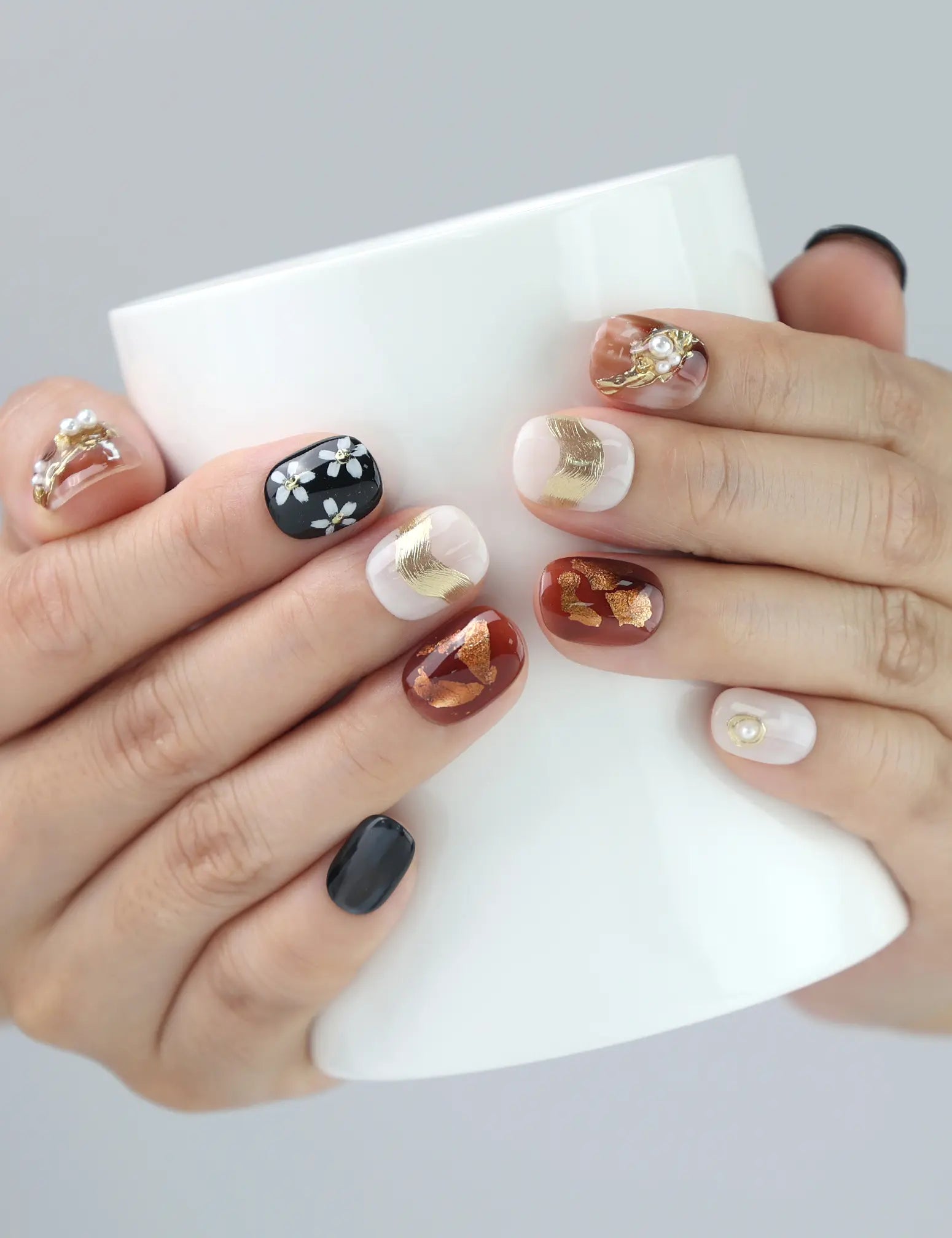 Woman holding ceramic mug while wearing Naillover Floral Glow press on nails, showcasing coquette-style floral elegance.