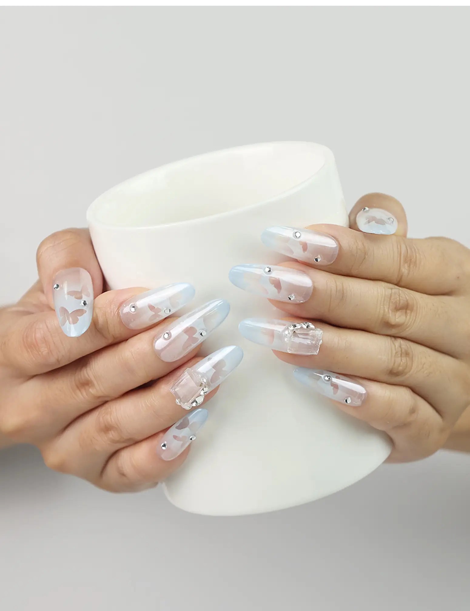 Hand holding a cup while wearing Frost White Singapore press-on nails with silver glitter, handmade by naillover