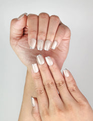 Hand close-up showing NailLover Frosted Glare handmade cat eye nails with metallic tips