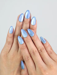 Hand wearing Naillover’s Frosted Skyline icy blue press on nails with soft cat eye shimmer.
