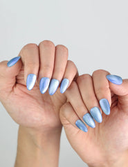 Fingers with Frosted Skyline nails by Naillover posed in winter styling, showcasing blue cat eye finish.
