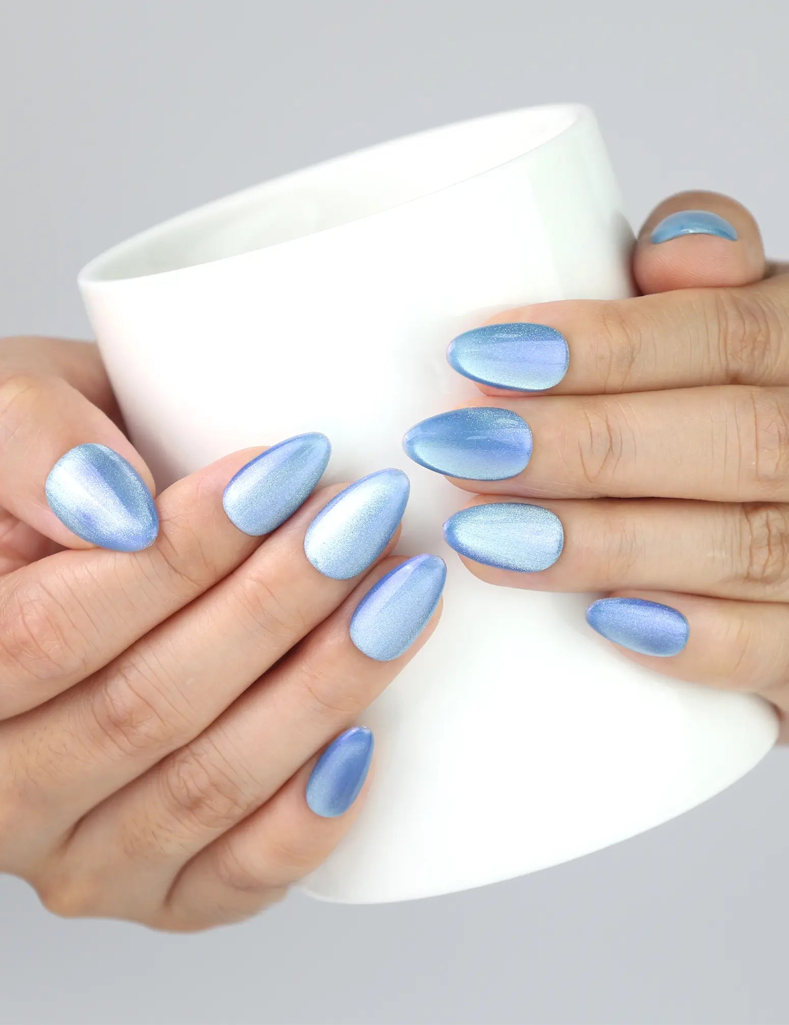 Naillover Frosted Skyline nails on hand holding a warm coffee cup, highlighting the frosty cat eye effect.