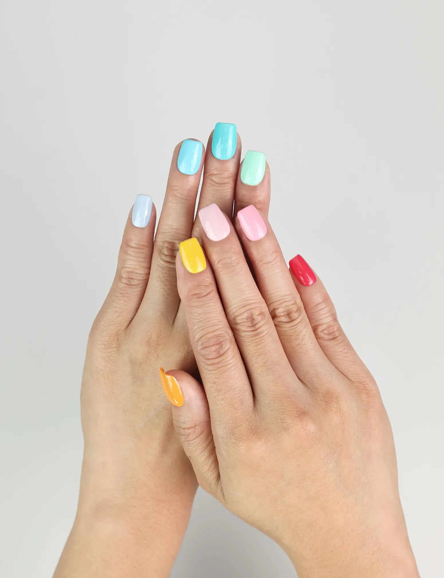 Model wearing Fruit Punch handmade Singapore press on nails in bright fruity colors – close-up view