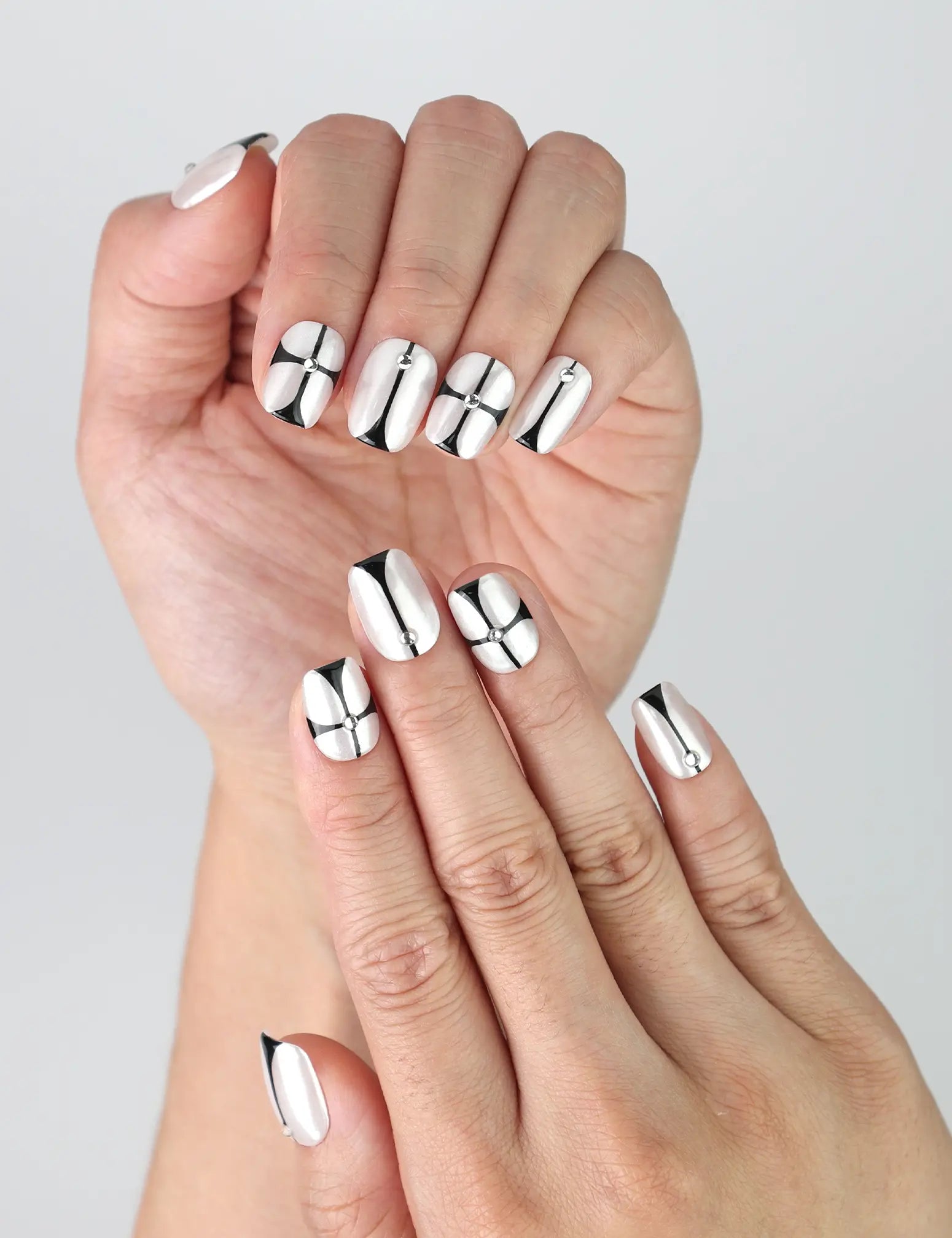 Close-up of Naillover handmade short nude nails with squoval shape and modern black chrome lines and angles