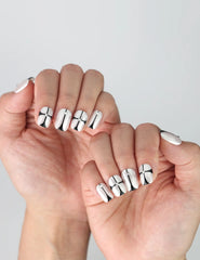 Side view showing glossy nude squoval press-on nails with bold, futuristic black chrome geometric accents
