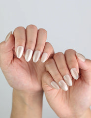 Natural daylight shot of Glimmer Dust nails worn on hand, reflecting gold shimmer with a clean, soft finish.